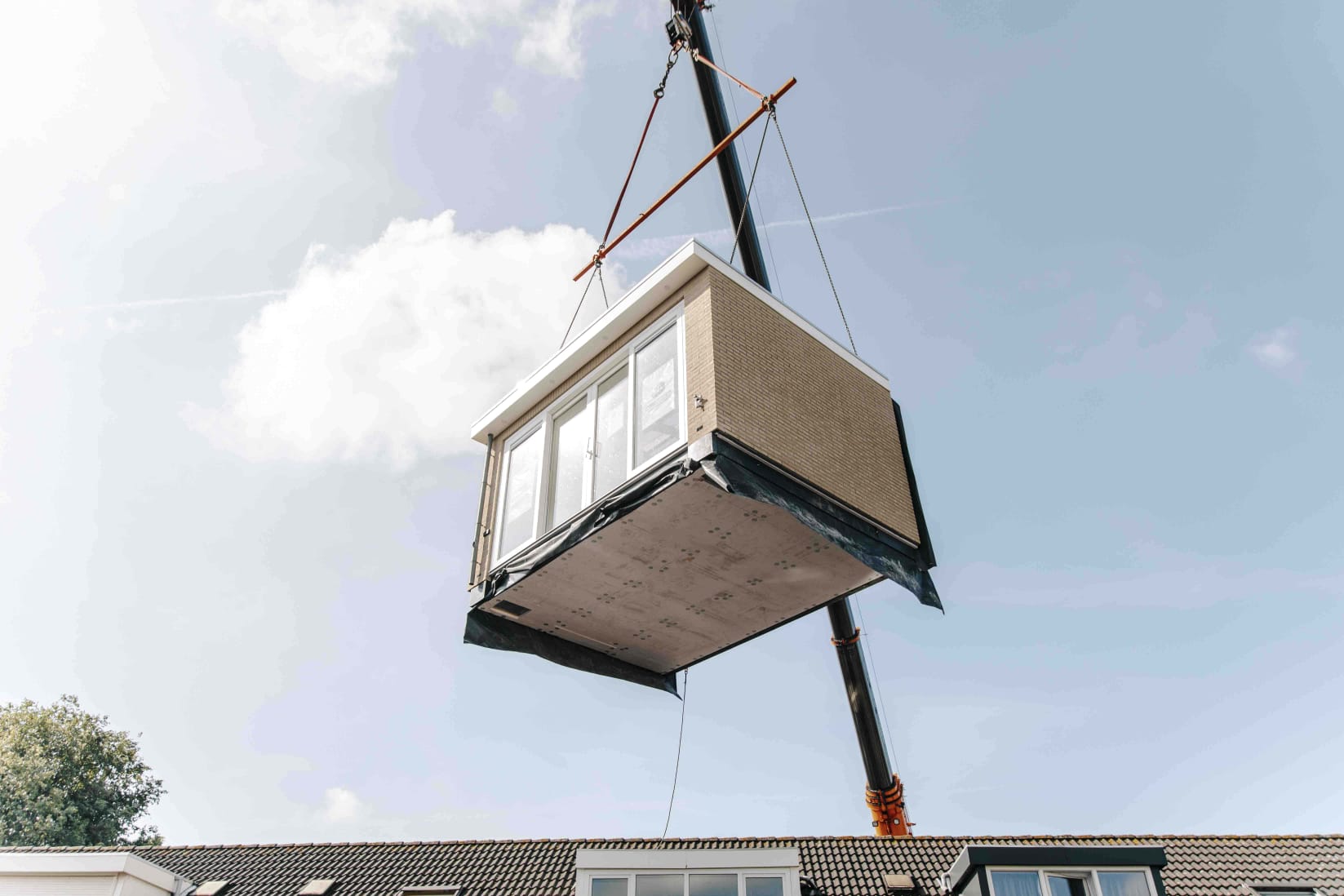 Prefab aanbouw die op locatie wordt geplaatst en aansluit op de bestaande gevel van de woning.