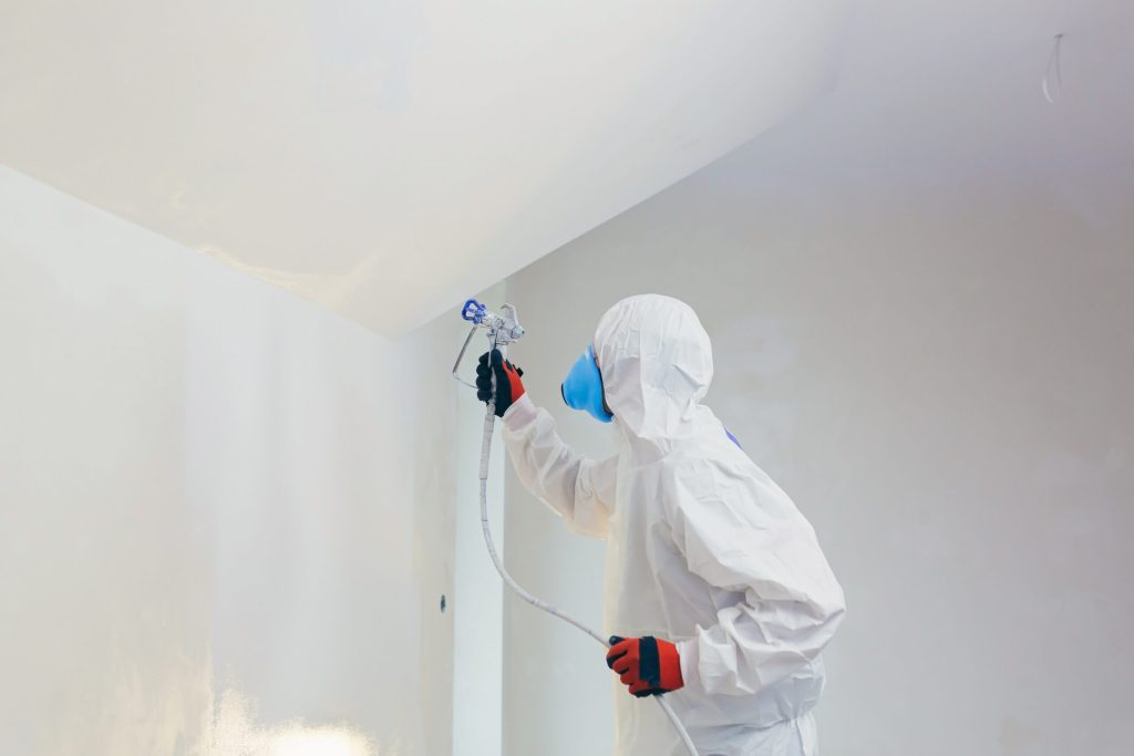 Muren spuiten door professionele schilder in moderne woonkamer met strakke egale afwerking