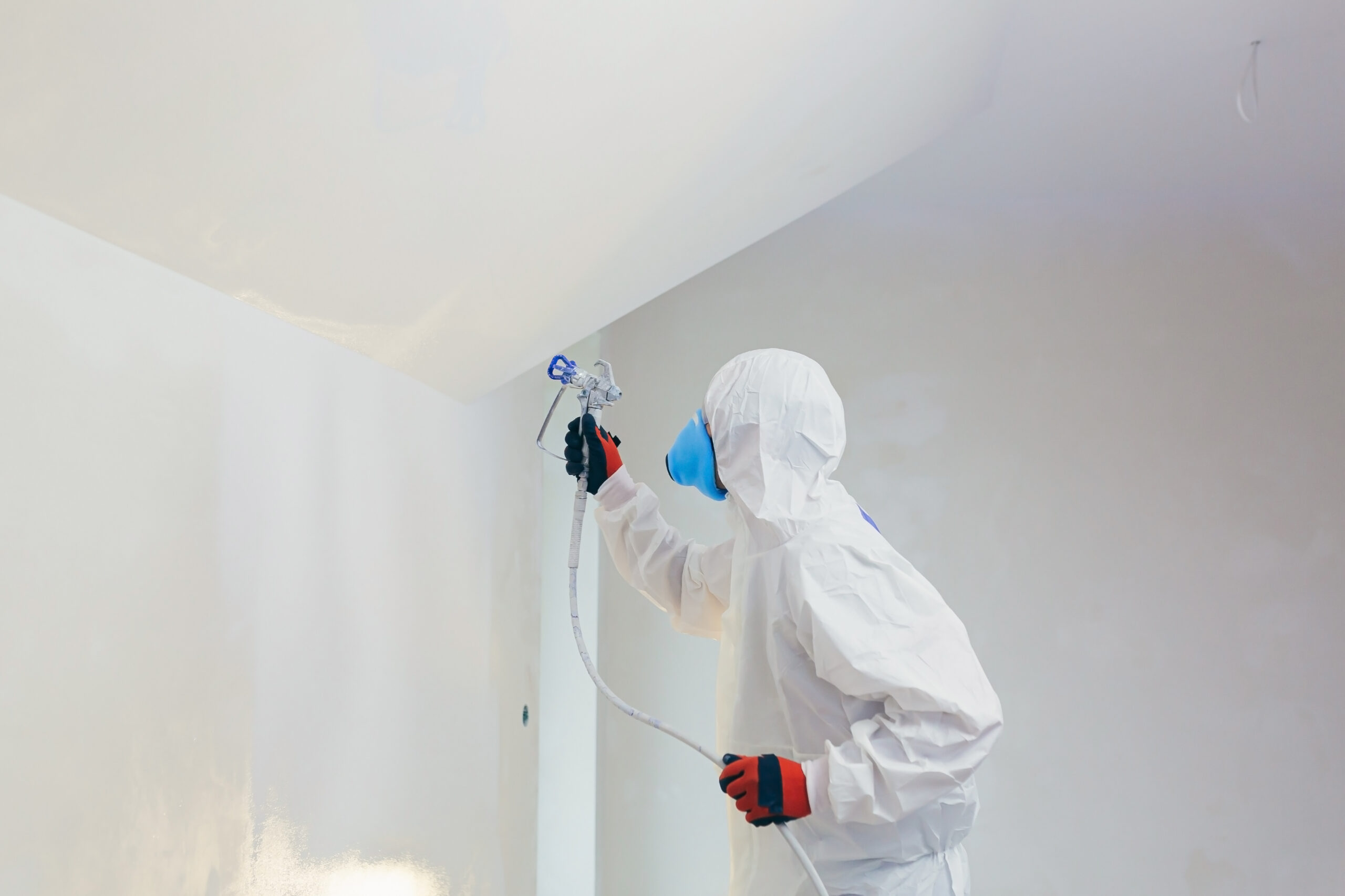 Muren spuiten door professionele schilder in moderne woonkamer met strakke egale afwerking