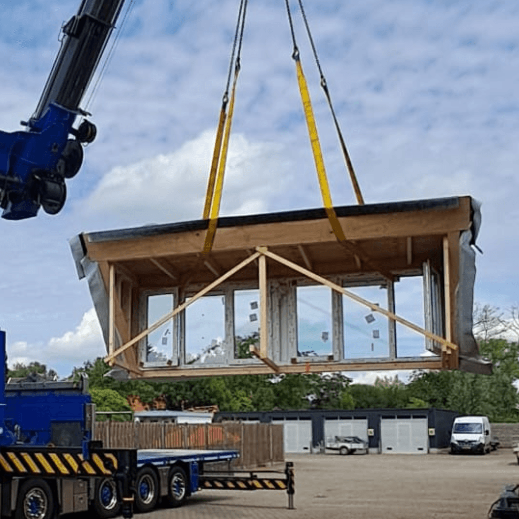 Prefab dakkapel wordt op het huis gezet door een kraan
