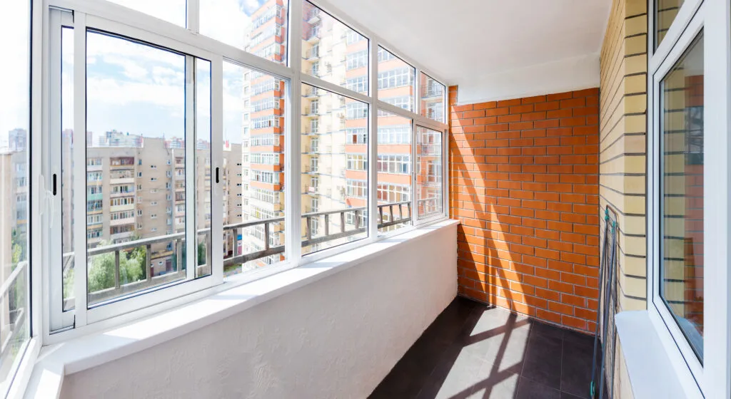Woninggevel met zonwerend glas dat zonnewarmte beperkt zonder het uitzicht volledig te blokkeren.