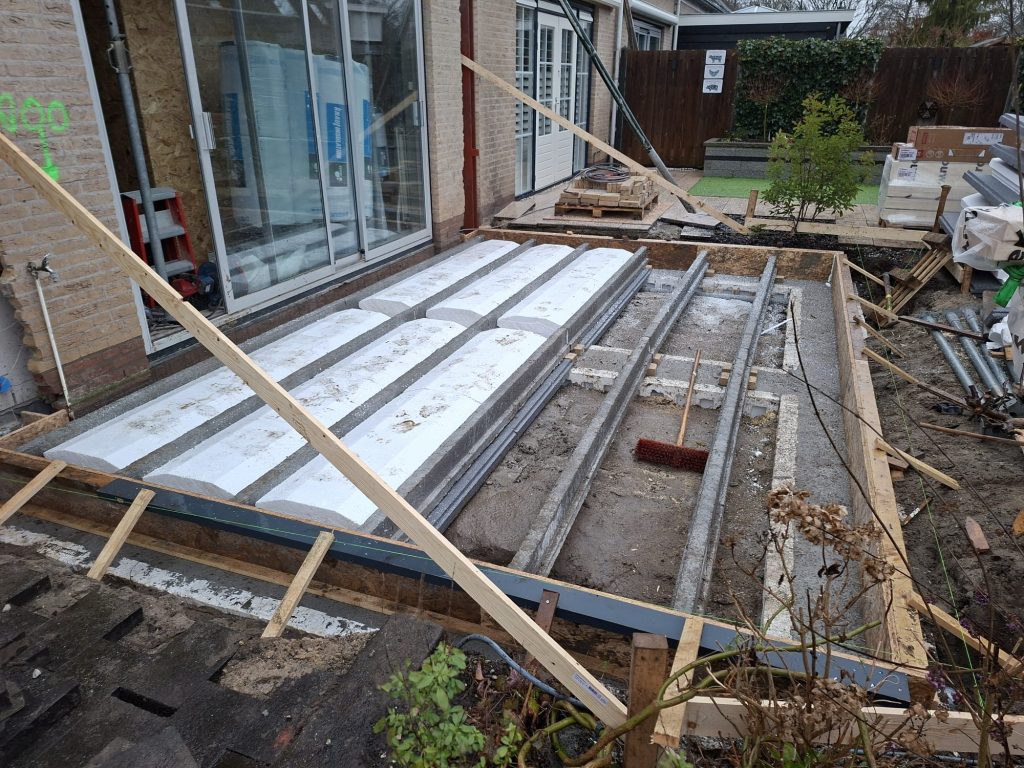 Fundering voor een traditionele aanbouw met bekisting en voorbereiding voor een stabiele constructie.
