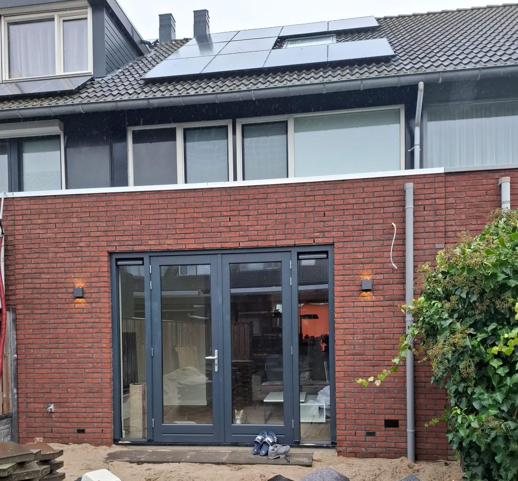 Traditionele aanbouw met gevelbekleding die aansluit op de stijl van de bestaande woning