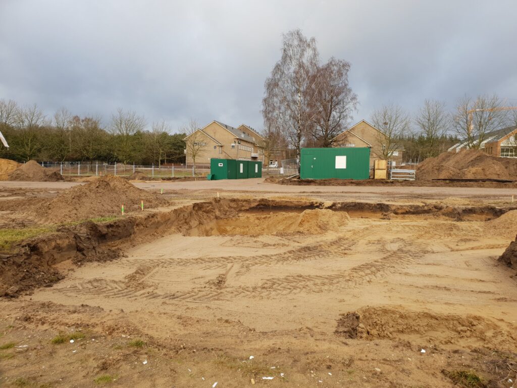 Grondwerk voor het plaatsen van een prefab kelder onder een woning