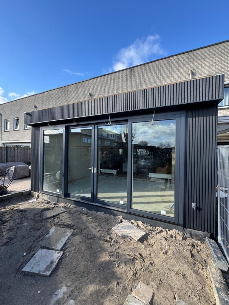 Uitbouw aan de achterzijde van een woning voor een grotere woonkamer en betere verbinding met de tuin.