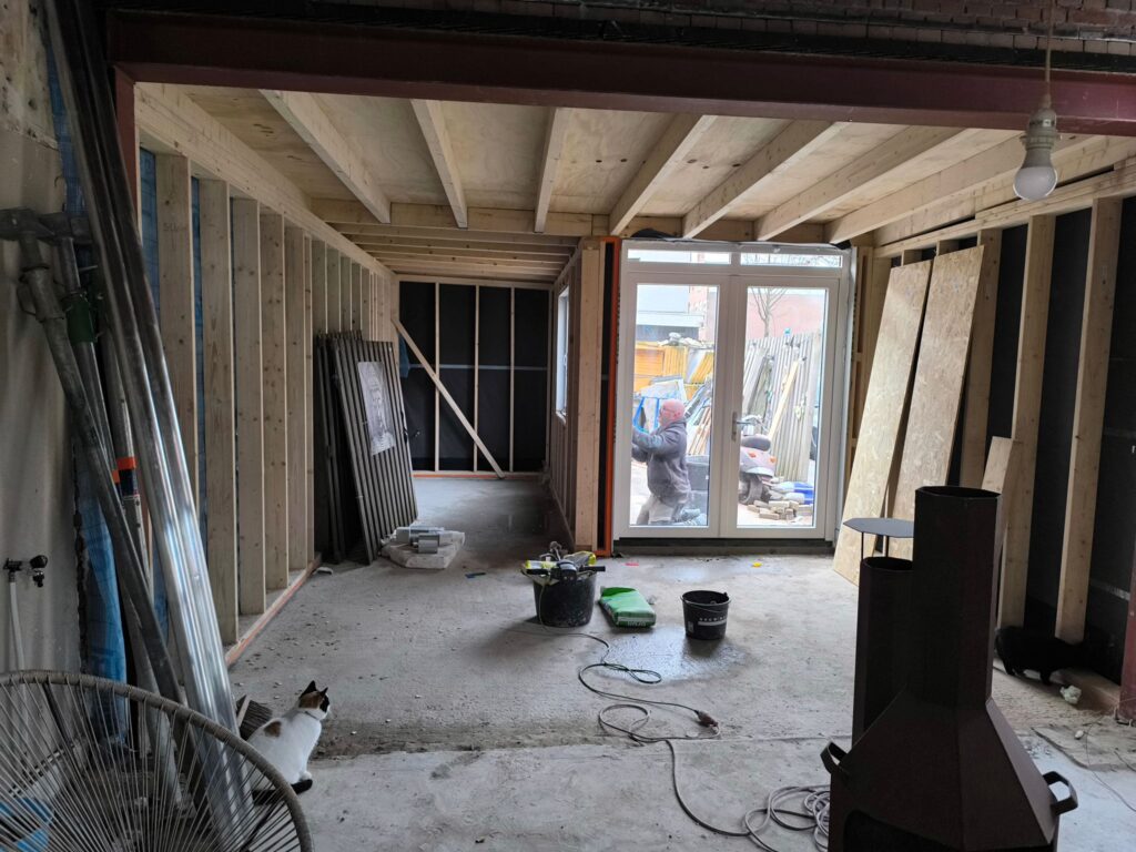 Traditionele aanbouw in houtskeletbouw met maatwerkconstructie en aansluiting op bestaande woning.