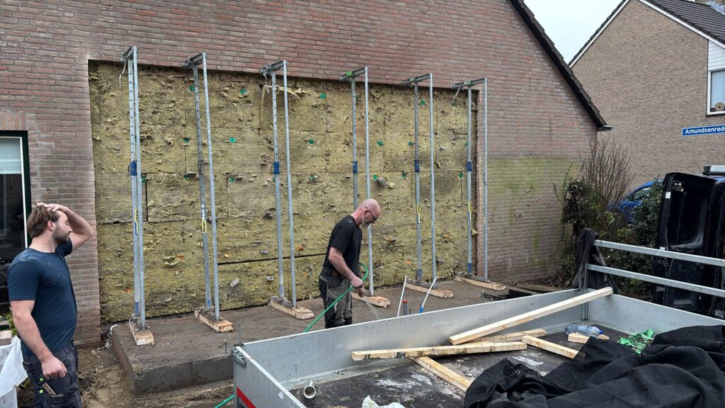 Doorbraak maken voor de aanbouw voor het opvangen van de zijgevel